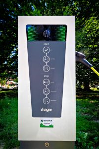 Borne de recharge électrique installée par Pouchain, montrant les instructions d'utilisation et les connexions pour les véhicules électriques.